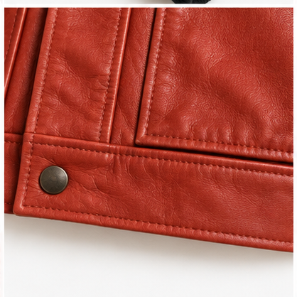 Detalle de cuero, costuras y botón de la chaqueta roja para dama